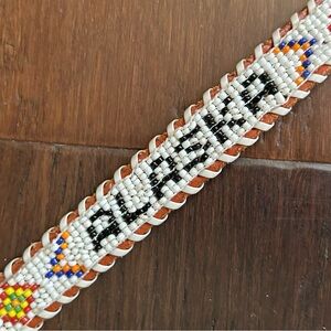 Childs handcrafted souvenir belt from Alaska with beaded detail. Brown leather.